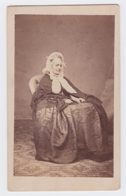 Femme assise portant une coiffe blanche nouée par un large rubanc