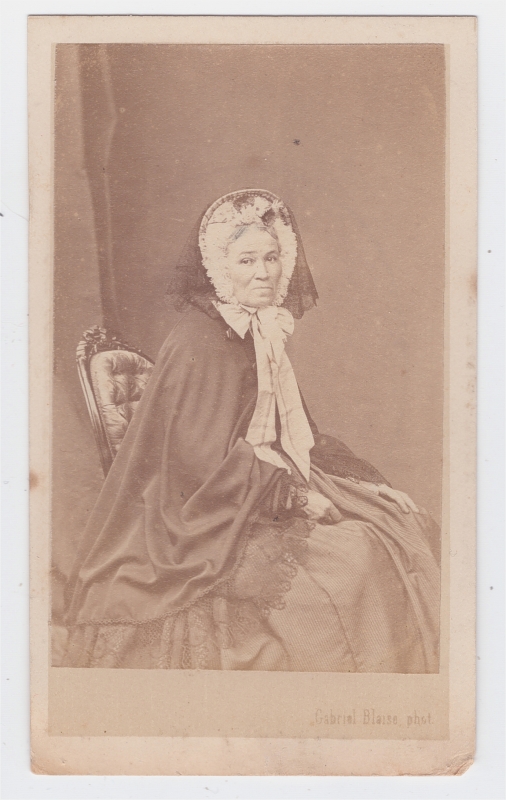 Femme assise en tenue de ville portant une voilette sur sa coiffe