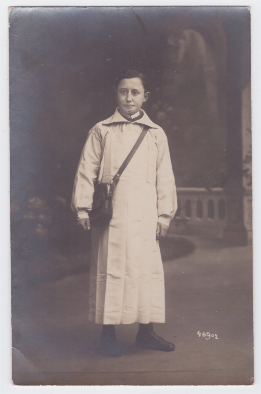 Jeune employé de commerce (?) en blouse blanche et portant une sacoche