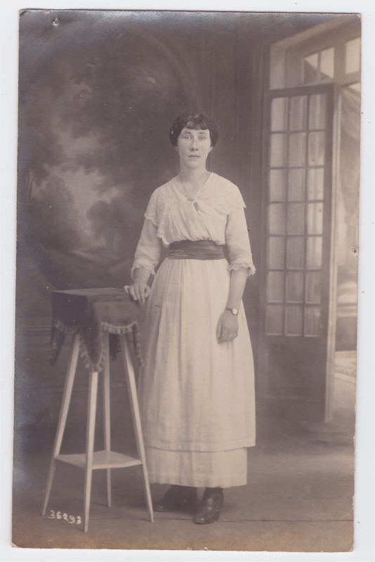 Jeune femme en longue robe blanche posant près d'une sellette
