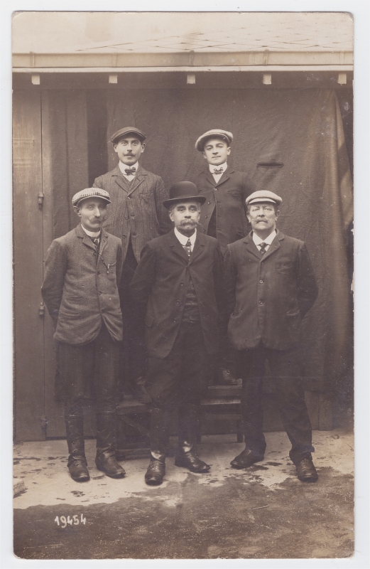 Cinq hommes posant dans une cour