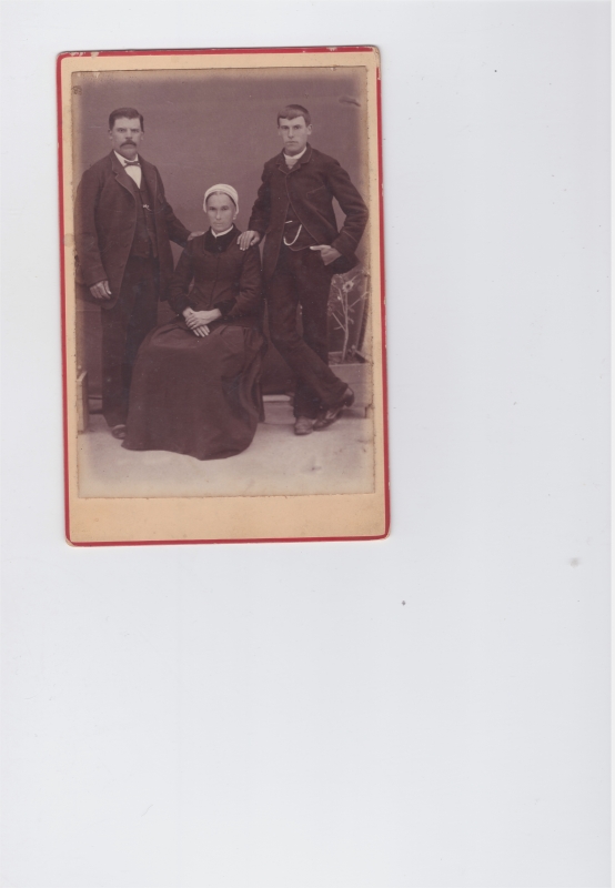 Femme assise entre deux hommes (son mari et son fils ?)