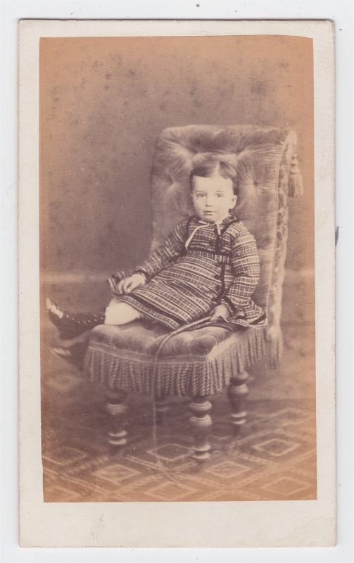 Enfant assis tenant une cravache