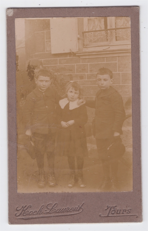 Trois enfants devant une maison
