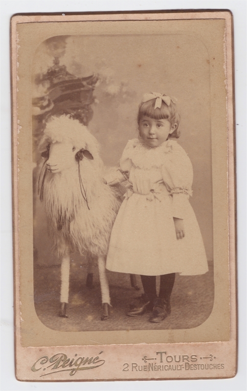 Fillette posant près d'un mouton factice