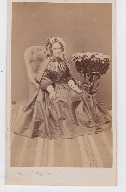 Femme portant une coiffe fleurie avec de larges rubans de chaque côté