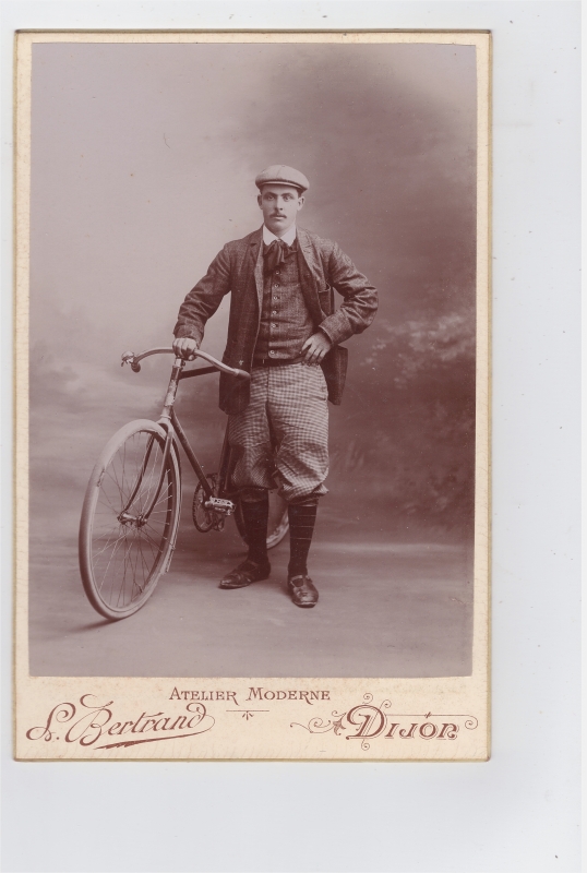 Homme posant en atelier avec sa bicyclette