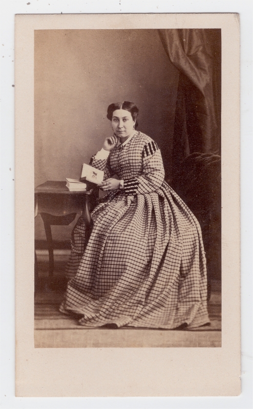 Femme assise, portant une robe à carreaux